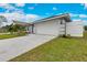 Charming home featuring a manicured lawn, a two-car garage and a modern design with decorative column accents at 271 Antis Dr, Rotonda West, FL 33947