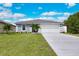 Charming single-story home with a well-maintained lawn, mature palm trees, and a two-car garage at 271 Antis Dr, Rotonda West, FL 33947