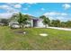 Well-manicured front lawn featuring young palm trees and a freshly poured driveway at 271 Antis Dr, Rotonda West, FL 33947