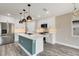 Bright, modern kitchen with stainless steel appliances, island with quartz countertop, and stylish pendant lighting at 271 Antis Dr, Rotonda West, FL 33947