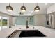 Kitchen island featuring a deep sink, stainless steel appliances and modern pendant lighting at 271 Antis Dr, Rotonda West, FL 33947