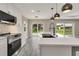 Modern kitchen with island, stainless steel appliances, tile backsplash, and a view of the backyard at 271 Antis Dr, Rotonda West, FL 33947