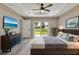 Bright main bedroom featuring a ceiling fan, television, sliding glass door and sleek, neutral color scheme at 271 Antis Dr, Rotonda West, FL 33947
