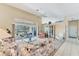 Bright living room with vaulted ceilings, ceiling fan, sliding glass doors to the pool area, and floral pattern furniture at 285 Spaniards Rd, Placida, FL 33946