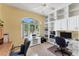 Bright office space featuring custom built-in shelving and cabinets, with a large arched window providing natural light at 285 Spaniards Rd, Placida, FL 33946