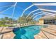 Relaxing screened-in pool area with connected spa, surrounded by brick pavers and lush landscaping for privacy at 285 Spaniards Rd, Placida, FL 33946