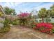 Lush driveway featuring an attractive wooden pergola adorned with flourishing bougainvillea climbing all over the structure at 365 Capstan Dr, Placida, FL 33946