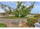 View of the front yard featuring a mature shade tree with lush green foliage over the circular driveway at 365 Capstan Dr, Placida, FL 33946