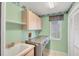 Laundry room with washer and dryer, utility sink, cabinets, and window at 365 Capstan Dr, Placida, FL 33946