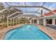 Sparkling screened-in pool offering a private and refreshing oasis, enhanced by lush landscaping and a brick patio at 365 Capstan Dr, Placida, FL 33946