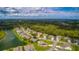 Scenic aerial view of homes nestled in a green neighborhood with a nearby pond at 399 Blue Springs Ct # 203, Englewood, FL 34223