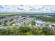 Wide aerial view of a quiet neighborhood near a pond, surrounded by lush greenery at 399 Blue Springs Ct # 203, Englewood, FL 34223