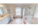 Bright bathroom with double vanity, stand alone tub, glass shower, and neutral decor at 399 Blue Springs Ct # 203, Englewood, FL 34223