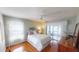 Bedroom features wood floors, neutral paint, a ceiling fan, and sliding door to balcony at 399 Blue Springs Ct # 203, Englewood, FL 34223