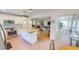 Open kitchen view showcasing island, stainless appliances, and connection to living area at 399 Blue Springs Ct # 203, Englewood, FL 34223