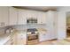 Well-appointed kitchen with stainless steel oven, white cabinetry and marble countertops at 399 Blue Springs Ct # 203, Englewood, FL 34223