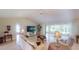 Inviting living room with tiled flooring, ceiling fan and access to a screened lanai with abundant natural light at 399 Blue Springs Ct # 203, Englewood, FL 34223