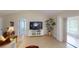 Cozy living room featuring tile flooring, a large television, and a decorative plant at 399 Blue Springs Ct # 203, Englewood, FL 34223