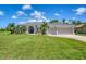Beautiful home showcasing a lush green lawn, swaying palm trees, and manicured landscaping at 423 Boundary Blvd, Rotonda West, FL 33947