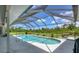 Refreshing swimming pool featuring a screened enclosure, a sun deck, and beautiful landscaping at 423 Boundary Blvd, Rotonda West, FL 33947
