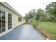 A concrete patio extends to a lush backyard featuring lawn, trees, and an outbuilding at 4371 Tollefson Ave, North Port, FL 34287
