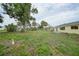 Large backyard offering mature shade trees, an open lawn, and potential for outdoor living at 4371 Tollefson Ave, North Port, FL 34287