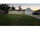 A single-story home at dusk, featuring a well-kept lawn and an attached one-car garage at 4371 Tollefson Ave, North Port, FL 34287