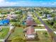 An aerial view of a charming single-story home with a well-manicured lawn and mature trees at 4399 Mundella Cir, Port Charlotte, FL 33948