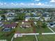 An aerial view displays a cozy home with a well-maintained lawn and mature trees at 4399 Mundella Cir, Port Charlotte, FL 33948