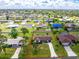 A charming single-story home featuring a well-manicured lawn with mature trees in a tranquil neighborhood setting at 4399 Mundella Cir, Port Charlotte, FL 33948