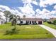 Aerial view of a well-kept single-story home with green lawn and long driveway at 4399 Mundella Cir, Port Charlotte, FL 33948