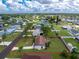 This aerial view showcases a cozy single-story home with well-kept lawn and mature landscaping at 4399 Mundella Cir, Port Charlotte, FL 33948