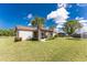 Well-maintained backyard with lush green grass, a palm tree, and an enclosed patio at 4399 Mundella Cir, Port Charlotte, FL 33948