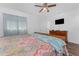 This bedroom features wood floors, a ceiling fan, a dresser, and a mounted TV at 4399 Mundella Cir, Port Charlotte, FL 33948
