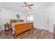 Cozy bedroom with wood floors, a ceiling fan, and a decorative wooden bedframe at 4399 Mundella Cir, Port Charlotte, FL 33948