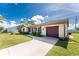 Charming single-story home featuring a well-manicured lawn and a driveway at 4399 Mundella Cir, Port Charlotte, FL 33948
