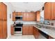 Well-appointed kitchen featuring wooden cabinets, stainless steel appliances, granite countertops, and tile flooring at 4399 Mundella Cir, Port Charlotte, FL 33948