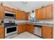 Kitchen featuring granite countertops, stainless steel appliances, tile flooring, and wooden cabinetry at 4399 Mundella Cir, Port Charlotte, FL 33948