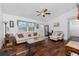 The comfortable living room has wood floors, a ceiling fan, neutral paint and ample seating at 4399 Mundella Cir, Port Charlotte, FL 33948