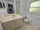 Bathroom with sink and commode, featuring a window for plenty of light at 4900 Hurley Ave, North Port, FL 34288