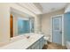 Cozy bathroom features blue tiling, vanity with a full mirror, and a separate toilet with an adjacent door at 5412 Ulysses St, Port Charlotte, FL 33981