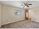 Spacious bedroom with neutral carpet, ceiling fan, window, and wood door leading to the hallway at 5412 Ulysses St, Port Charlotte, FL 33981