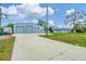 Large three-door garage with a concrete driveway leading to a well-maintained home at 5412 Ulysses St, Port Charlotte, FL 33981