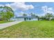Charming single-story home featuring a well-maintained lawn, attached garage, and inviting front entrance at 5412 Ulysses St, Port Charlotte, FL 33981