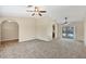 Living room with neutral walls, carpet flooring, arched doorways, and sliding glass doors to the pool at 5412 Ulysses St, Port Charlotte, FL 33981
