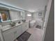 Bright bathroom features dual vessel sinks, white cabinetry, backlit mirror, and freestanding soaking tub at 608 Saint Judes Dr, Longboat Key, FL 34228