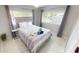 Sunlit bedroom boasts two windows, tiled floors, a neutral palette, and cozy furnishings at 608 Saint Judes Dr, Longboat Key, FL 34228