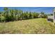 Sprawling green backyard with grass, shrubbery, and trees, providing ample outdoor space at 6293 Sparrow Ln, Englewood, FL 34224