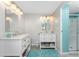 Bright bathroom with double vanities, modern fixtures, and a glass-enclosed shower stall at 6293 Sparrow Ln, Englewood, FL 34224