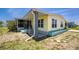 The side exterior view shows a screened-in porch and garden bed with a light-yellow mobile home at 6293 Sparrow Ln, Englewood, FL 34224